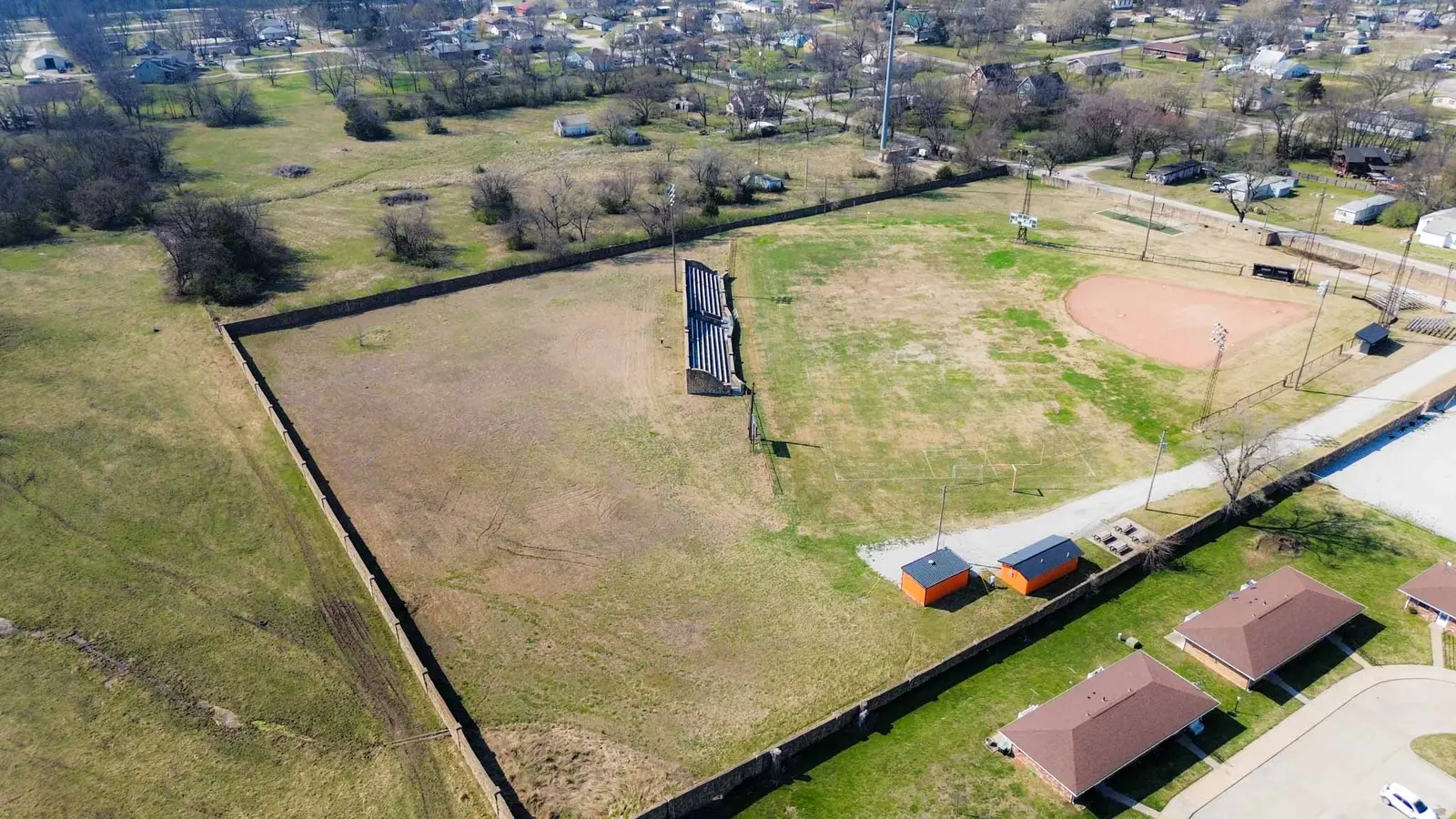 Aerial view of the ball diamond and open field with grandstand seating.